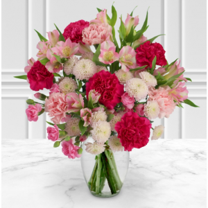 粉红色的百合水仙、粉红色的喷雾康乃馨、樱桃红和粉红色的康乃馨以及白色绒球喷雾菊花花束